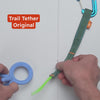 A product video that shows the uses of the trail tether ecosystem using mainly hands showing how the product works for securing toys, soothers, water bottles, keys, stroller items, in combination with chameleon rings and tether max